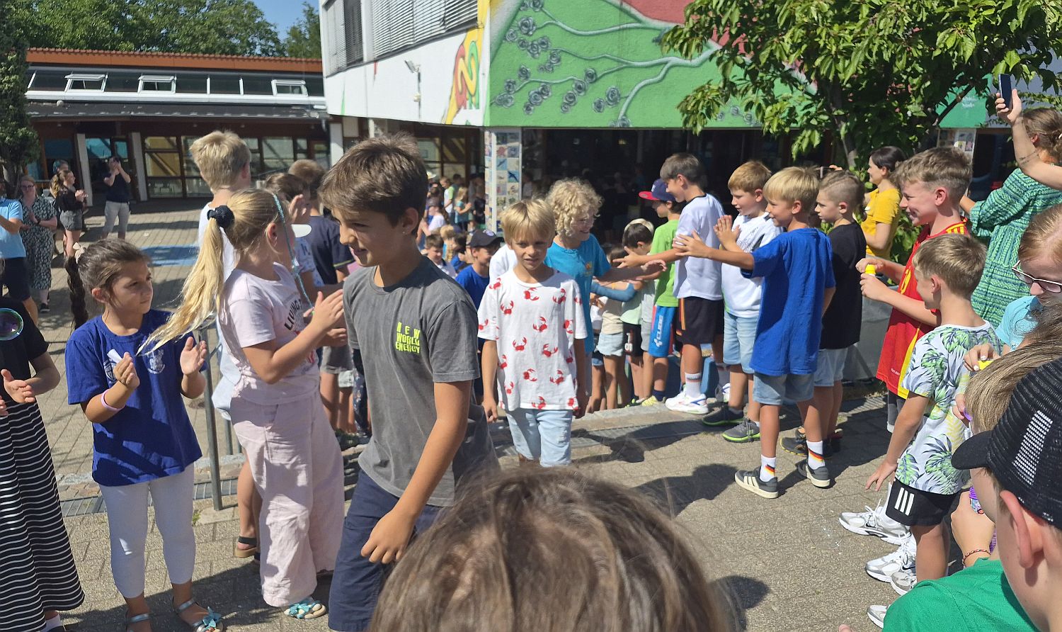 Foto mit Kindern, die durch ein Spalier aus Mitschülern laufen